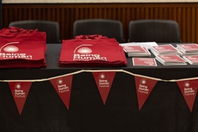 Tote bags and flyers on a table for the Being Human Festival 2024
