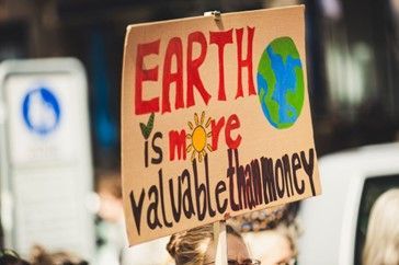 "Earth is more valuable than money" (Photo by Markus Spiske from Pexels: https://www.pexels.com/photo/climate-sign-outside-blur-2990617/) 