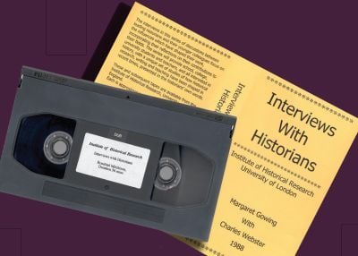 A black Betacam SP video cassette tape labeled "Institute of Historical Research – Interviews with Historians – Rosalind Mitchison, Duration 36 mins" sits diagonally atop a yellow printed cover titled Interviews With Historians. The cover indicates it was produced by the Institute of Historical Research, University of London, and features a 1988 interview between Margaret Gowing and Charles Webster. The text describes the series as academic discussions with historians about their influences and contribution